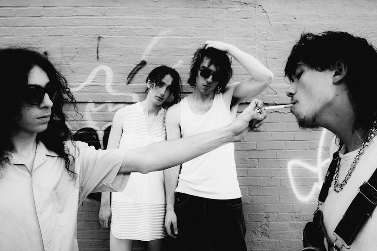 Black and white photo of American rock band Geese posing outdoors against a brick wall.